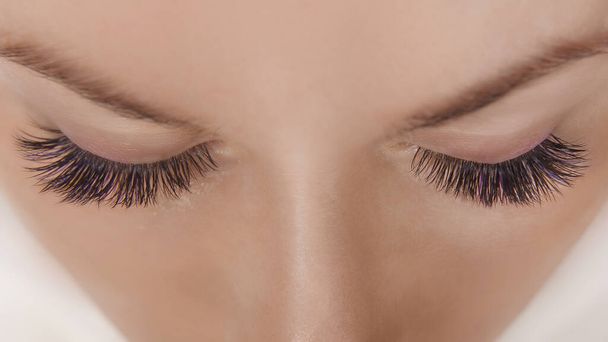 Procédure d'extension des cils. Vue rapprochée d'un bel œil féminin avec de longs cils, une peau lisse et saine. - Photo, image
