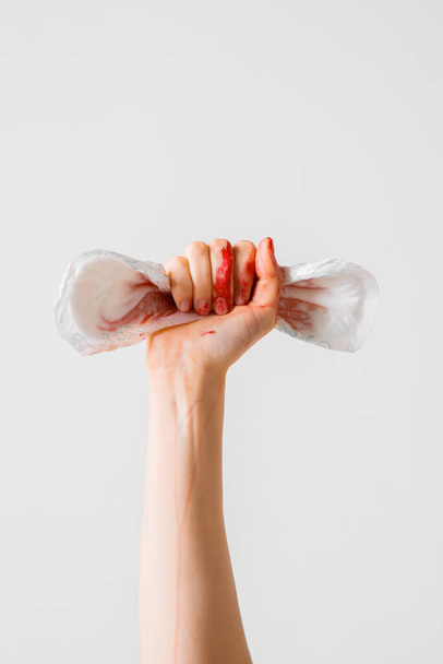 Womans fist as symbol of feminism with used menstrual pad, concept photography for feminist blog or poster - Zdjęcie, obraz