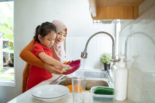 little Girl Help Her Mother In Washing Dishes - Φωτογραφία, εικόνα