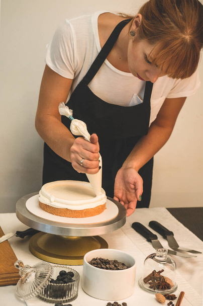 Η Εξομολογήτρια ετοιμάζει τούρτα. Η έννοια της ζαχαροπλαστικής, κέικ μαγειρικής - Φωτογραφία, εικόνα