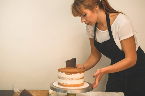 Makeistyttö valmistaa kakkua. Käsite leivonnaiset, ruoanlaitto kakut - Valokuva, kuva