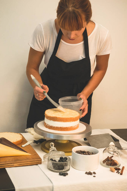Confectioner girl is preparing a cake. The concept of pastry, cooking cakes - Photo, Image