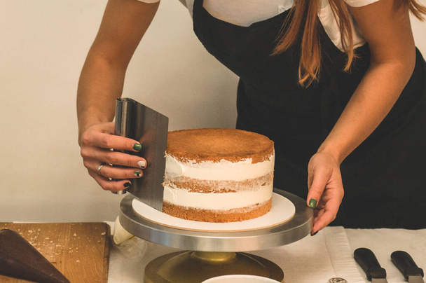 La pâtissière prépare un gâteau. Le concept de pâtisserie, gâteaux de cuisine - Photo, image
