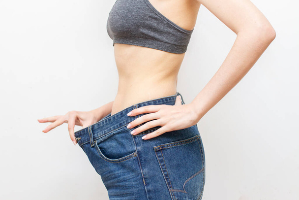 Donna in pantaloni oversize dopo la perdita di peso. Concetto di dieta. - Foto, immagini
