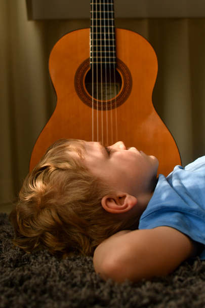 A boy playing acoustic guitar   - Фото, зображення