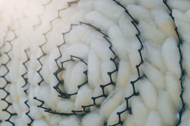 Sluiten tot natuurlijke witte zijde worm cocon shell in zwarte plastic weven lade. Zijderupsen cocon achtergrond. - Foto, afbeelding