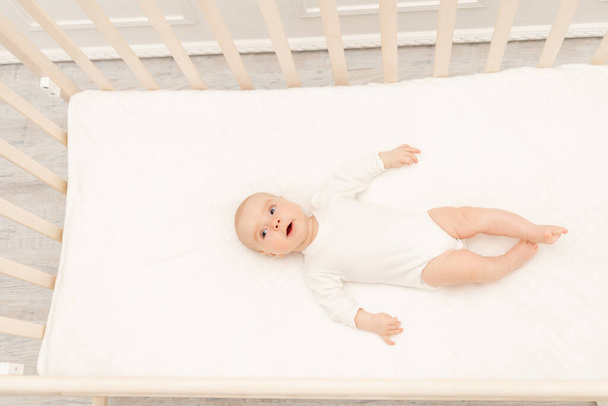 Sleeping baby and his toy in white crib. Nursery interior and bedding for kids. Cute little boy napping in bassinet. Kid taking a nap in white bedroom. Healthy child in bodysuit pajamas. - Fotoğraf, Görsel