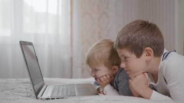 χαμογελαστός όμορφος παιδιά προσχολικής ηλικίας αρσενικό βλέποντας αστεία κινούμενα σχέδια ταινία στο φορητό υπολογιστή - Πλάνα, βίντεο