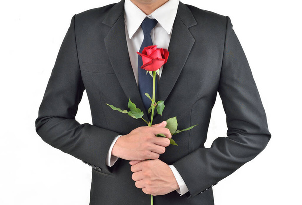 Un uomo d'affari che tiene fiori Belle rose rosse su uno sfondo bianco. - Foto, immagini