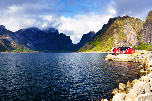 Famous tourist attraction Hamnoy fishing village on Lofoten Islands, Norway with red and yellow rorbu houses. Calm, blurred water - Photo, Image
