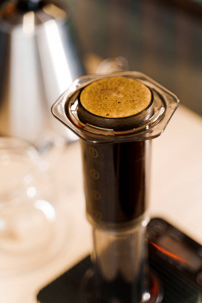 Aeropress im Loft-Café. Aeropress ist ein Gerät zum Aufbrühen von Kaffee. Alternative skandinavische Methode der Kaffeezubereitung in Kaffee, Barista macht Kaffee - Foto, Bild