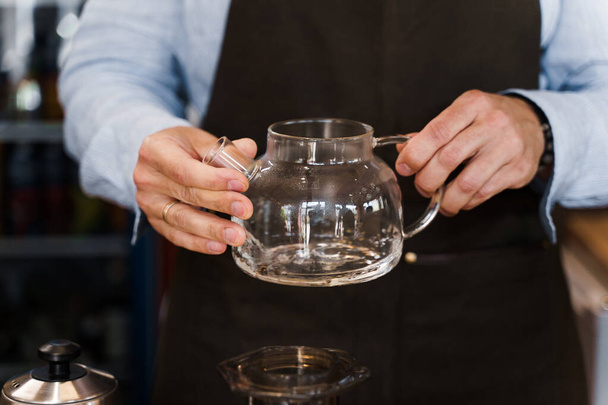 Barista tourne dans les mains et regarde le pot avec du café avant de faire de l'aération. Processus de brassage du café. Méthode de brassage du café scandinave - Photo, image