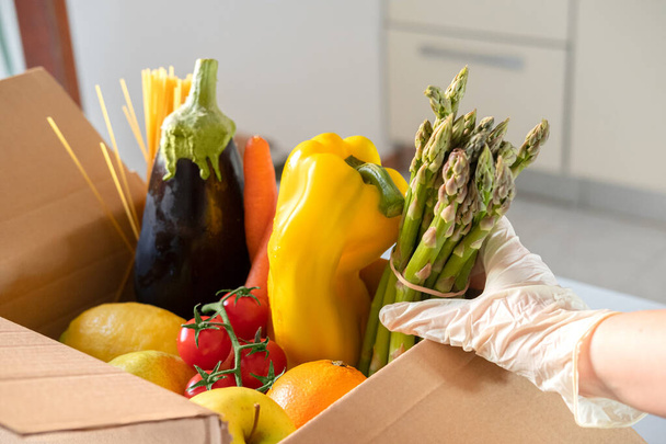スーパーフードの果物や野菜と募金箱。食料概念を共有する。フードデリバリー食品を集めるボランティア。コロナウイルスのパンデミック支援。トップ表示 - 写真・画像