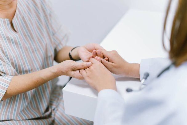 Nahaufnahme Arzt hält Hand des älteren Patienten, medizinische Versorgungsverantwortung - Foto, Bild
