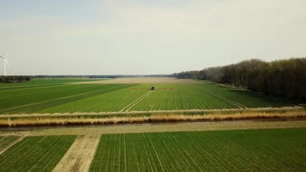 luchtfoto 's van landbouwmachines die pesticiden sproeien over landbouwgrond - Video
