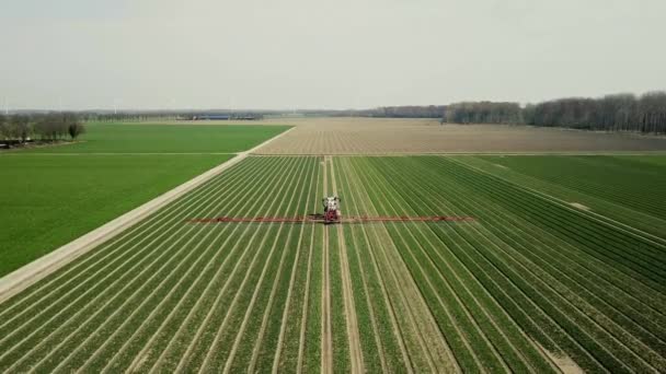 luchtfoto 's van landbouwmachines die pesticiden sproeien over landbouwgrond - Video