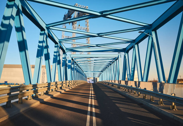 Günbatımında sanayi bölgesinde modern bir yol köprüsünün ön görüntüsü. - Fotoğraf, Görsel
