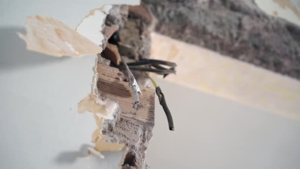 Wires twisted with insulting tape hanging from the apartment wall, bare high voltage cables are in risk of short circuit. Bad electrician service work, dangerous wires and unsafety concept - Footage, Video