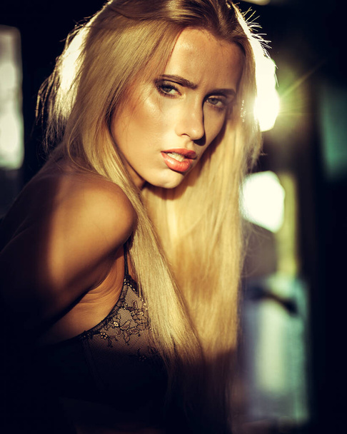 Mode und Dessous-Konzept - schöne blonde Dame Porträt trägt sexy BH und Höschen in Loft-Stil Interieur. Frau in Unterwäsche posiert auf einem Fenster im Kontrast von Licht und Schatten. - Foto, Bild