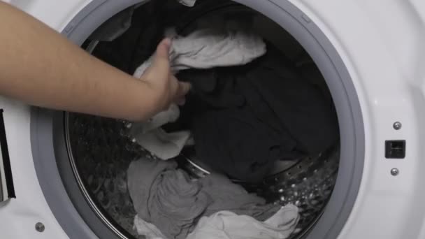 Unrecognizable person putting gloves and medical mask in a washing machine. New normality concept. - Footage, Video