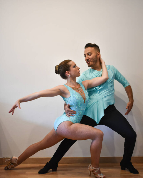 Profissional de dança latina casal posando enquanto dança em vestidos azuis claros
 - Foto, Imagem
