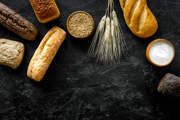 Set of loaves of bread on black desk from above copy space - Zdjęcie, obraz