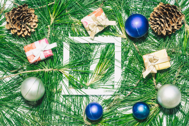 Vánoční pozadí s vánoční koule, dárky, borovice a zelené borovicové listy. Prázdné místo pro čtvercovou kopii textu - Fotografie, Obrázek