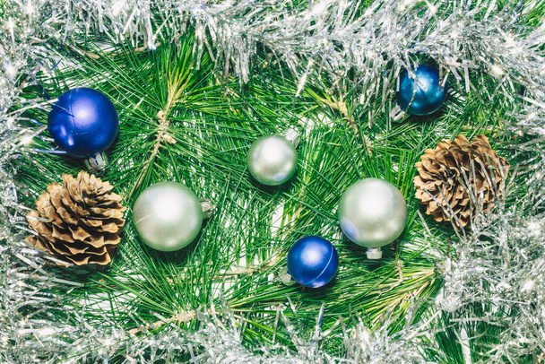 X-mas sfondo con decorazione in argento, palle di Natale, pigne e foglie di pino verde. - Foto, immagini