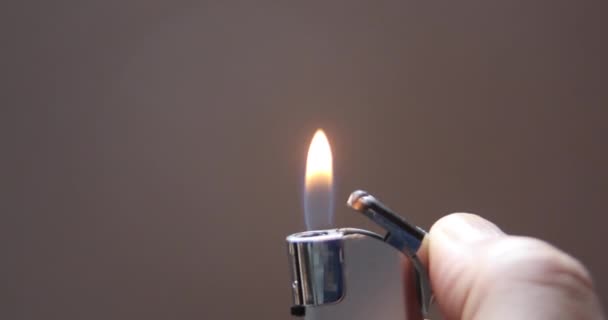 Feuerzeug brennt mit kleiner Flamme, um die Umgebung zu erleuchten - Filmmaterial, Video