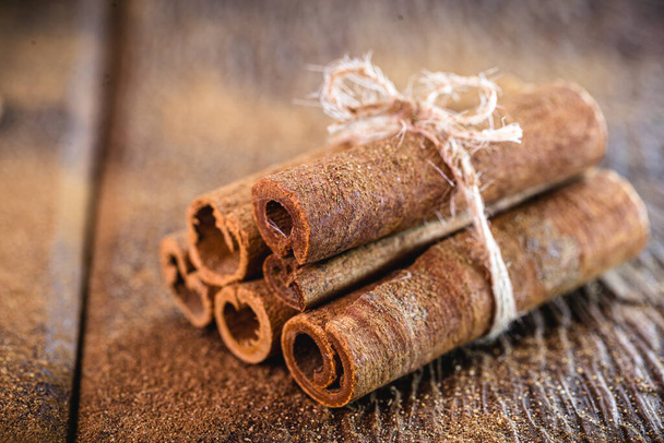 Cinnamon sticks isolated on background rustic wood. - Foto, imagen