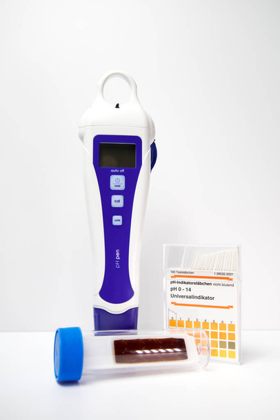laboratory equipment for fluid testing on pH and microbial growth. Translation right box: "100 test strips.pH-indicatorstrips, not bleeding. pH 0-14 universal indicator.Immerse - read wet." - Photo, Image