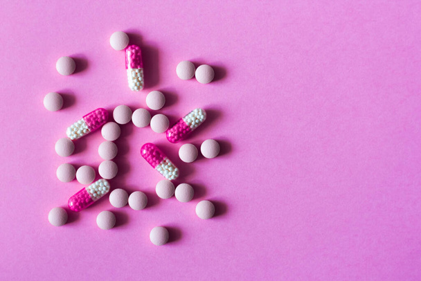 Heap of pills, tablets, capsules on pink background. Drug prescription for treatment medication health care concept wth copy space background - Photo, Image