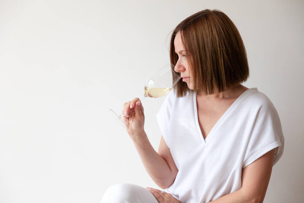 Кавказская брюнетка сомелье с бокалом белого вина - Фото, изображение
