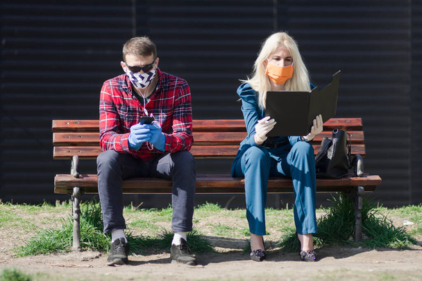 Lebensstil der Menschen in der COVID-19-Saison mit Schutzmaske und Schutzhandschuhen bei Pandemien. Draußen auf Bank sitzen. - Foto, Bild