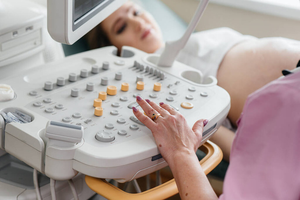 Συσκευή υπερήχων κατά τη διάρκεια ιατρικής εξέτασης εγκύου. Ιατρική εξέταση - Φωτογραφία, εικόνα