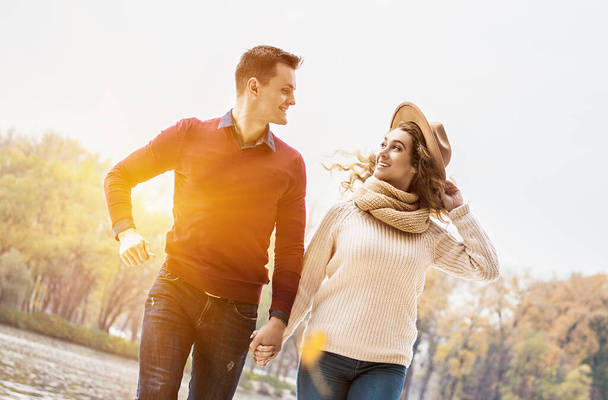 Happy to be together. Low-angle view young couple having fun outdoors. Handsome man and young woman holding their hands together while running outdoors. Cheerful couple in love. Togetherness concept - Фото, зображення
