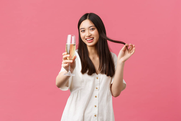 Celebration, party holidays and fun concept. Flirty and coquettish young woman with glass champagne trying seduce guy on celebrating event, laughing and smiling silly, saying cheers - Фото, изображение