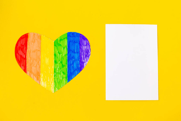Coração em cores lgbtq e branco mockup em branco no fundo amarelo brilhante, vista superior, espaço de cópia
 - Foto, Imagem