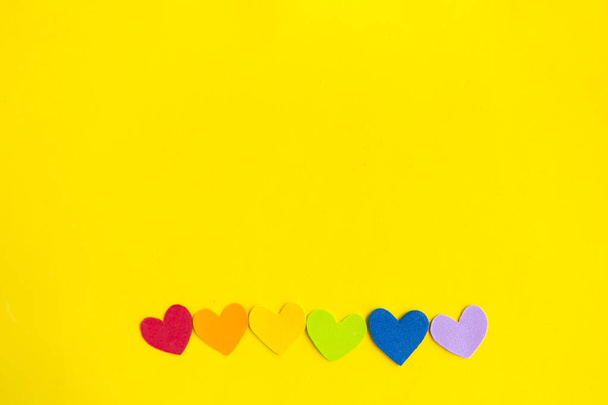 Hearts in lgbtq colors on bright yellow background, top view, copy space - Φωτογραφία, εικόνα