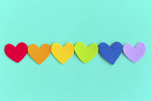 Herzen in lgbtq-Farben auf grünem Minzhintergrund, Draufsicht - Foto, Bild