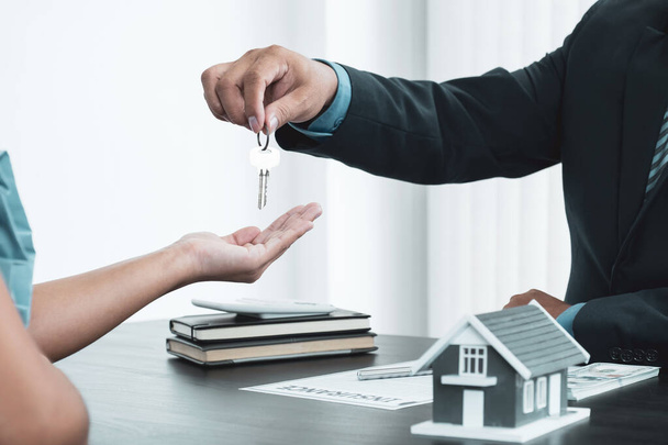 Hand a real estate agent, hold the keys, and explain the business contract, rent, buy, mortgage, loan, or home insurance. - Foto, imagen