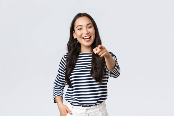 Lifestyle, beauty and fashion, people emotions concept. Happy cheerful asian girl praising you, picking person, found excellent employee for job position, pointing camera and smiling - Photo, Image