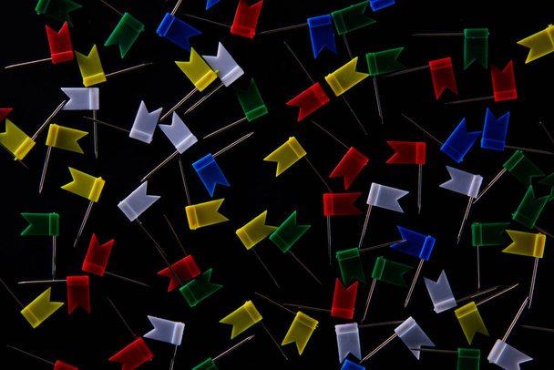разноцветные канцелярские флажки в форме маркера карты булавки на черном фоне, близкий вид
   - Фото, изображение