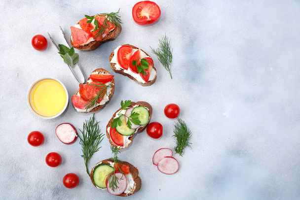 Dietary bruschetta with cheese, cucumber, radish and red fish, healthy breakfast with ingredients. Healthy and natural food concept, lifestyle, flat lay, - Фото, изображение