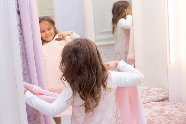 Girl trying on clothes in a fitting room in a clothing store. - 写真・画像