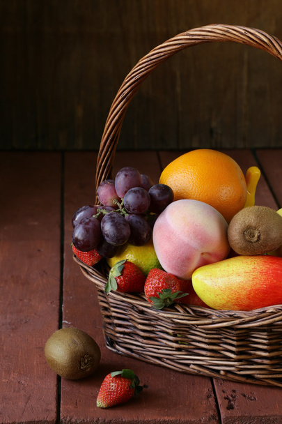 Still life wicker basket with fruit on a wooden table - Foto, Bild