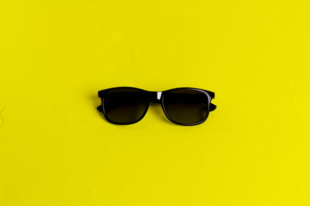 sunglasses isolated in a yellow background. - Foto, imagen