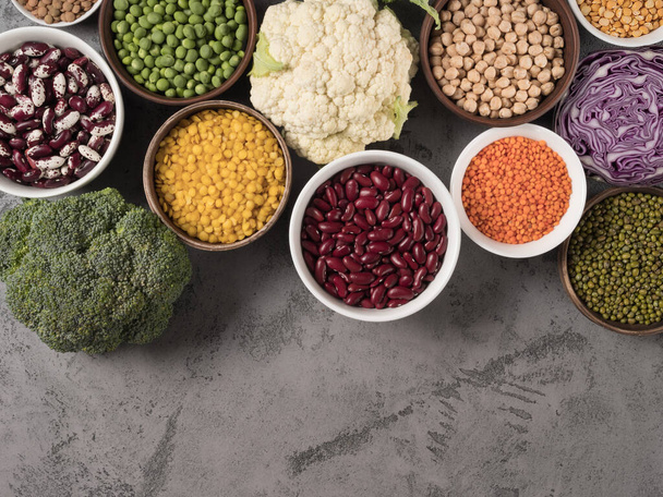 Assorted fresh cabbage and different legumes on gray background. - Photo, Image