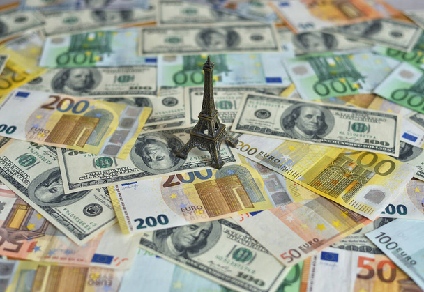 Tour Eiffel sur une table avec de l'argent. Chiffre relatif au dollar et aux billets en euros. Concept de voyage et d'argent - Photo, image