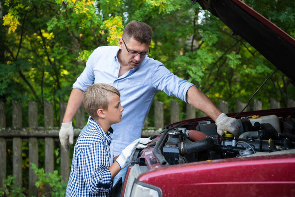 Um pai e um filho trabalhando juntos restaurando um motor de seu caminhão
 - Foto, Imagem